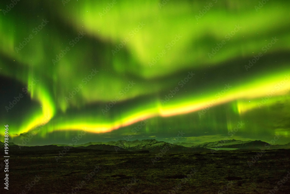 A wonderful night with Kp 5 . Northern lights mountain in Iceland. Background blurred.