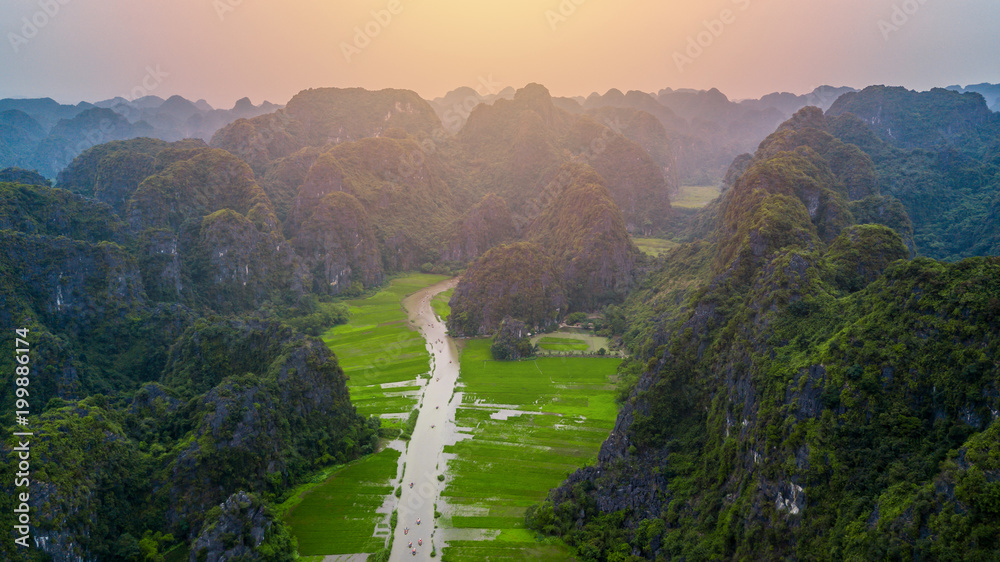 鸟瞰游客乘船沿着Ngo Dong河旅行，并拍摄Tam Coc，R的照片