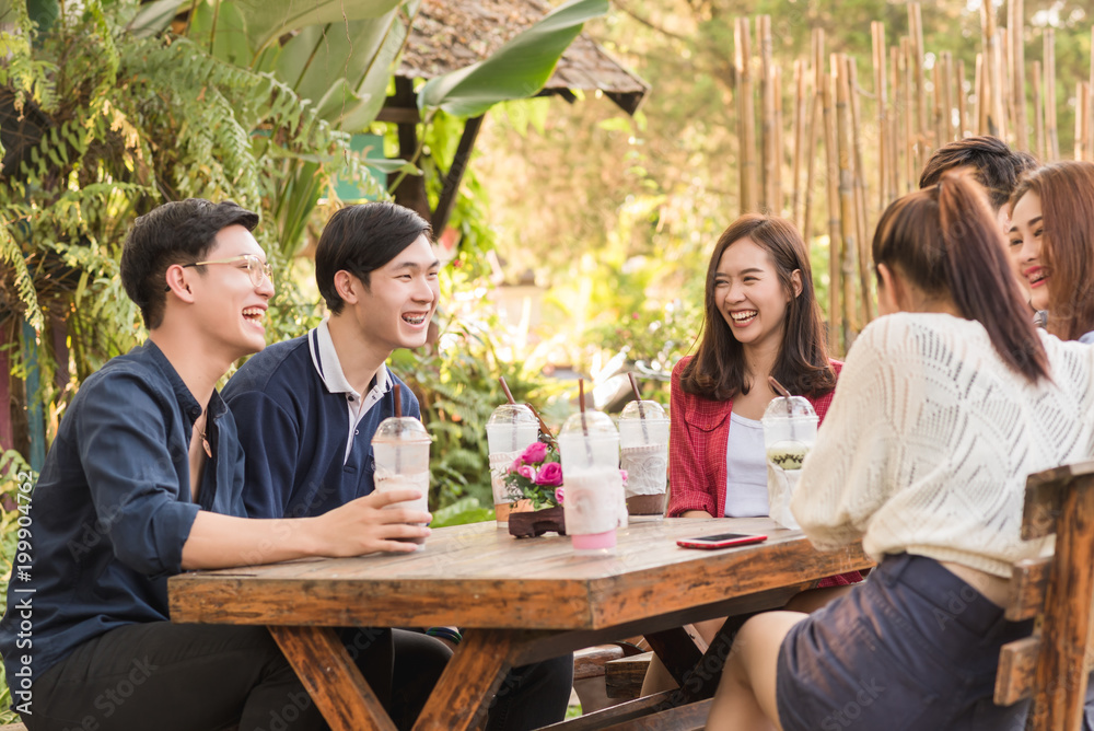 Group of six teenagers having fun together in coffee shop on the afternoon