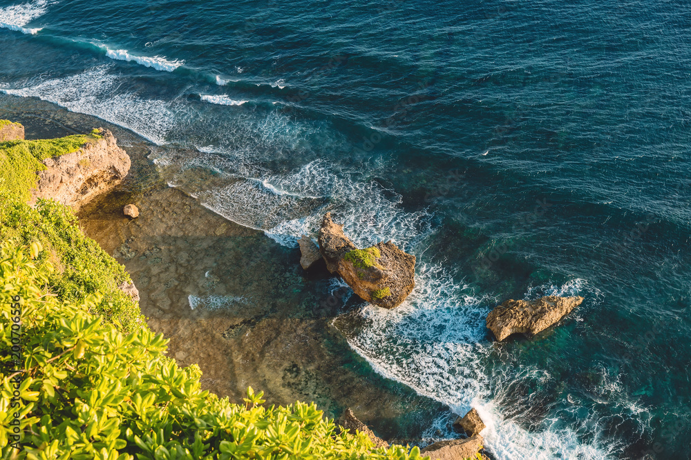 日落时分，巴厘岛乌鲁瓦图的海浪和悬崖构成的海洋