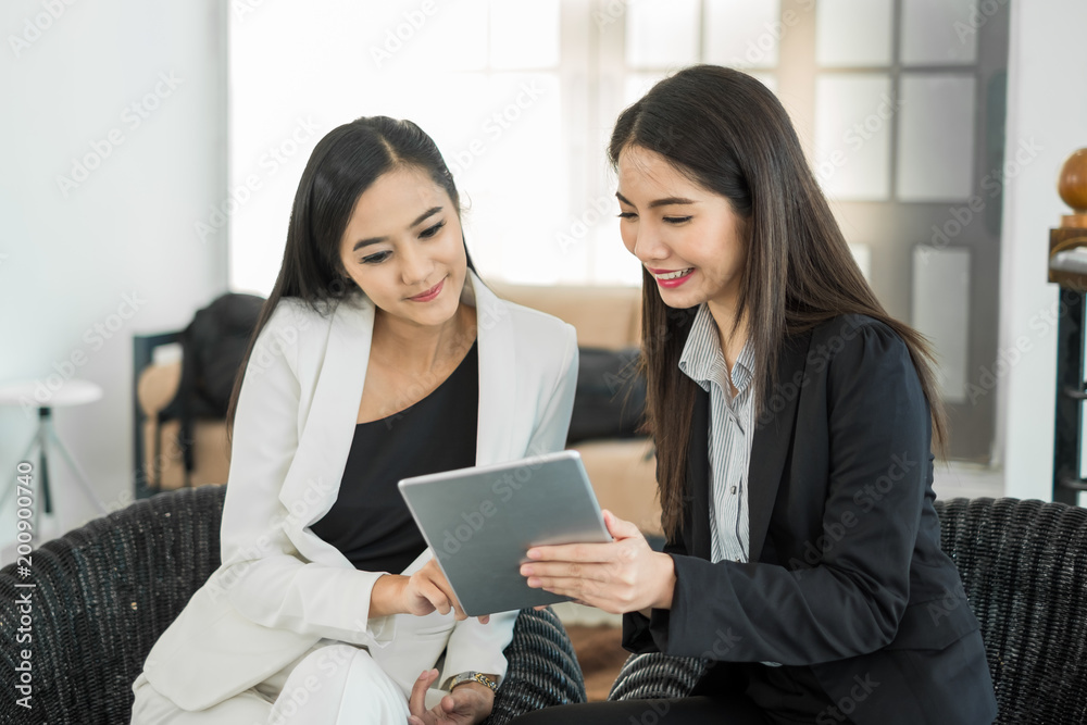 年轻的亚洲女商人在现代办公室里，在会议和会议中与同事讨论业务