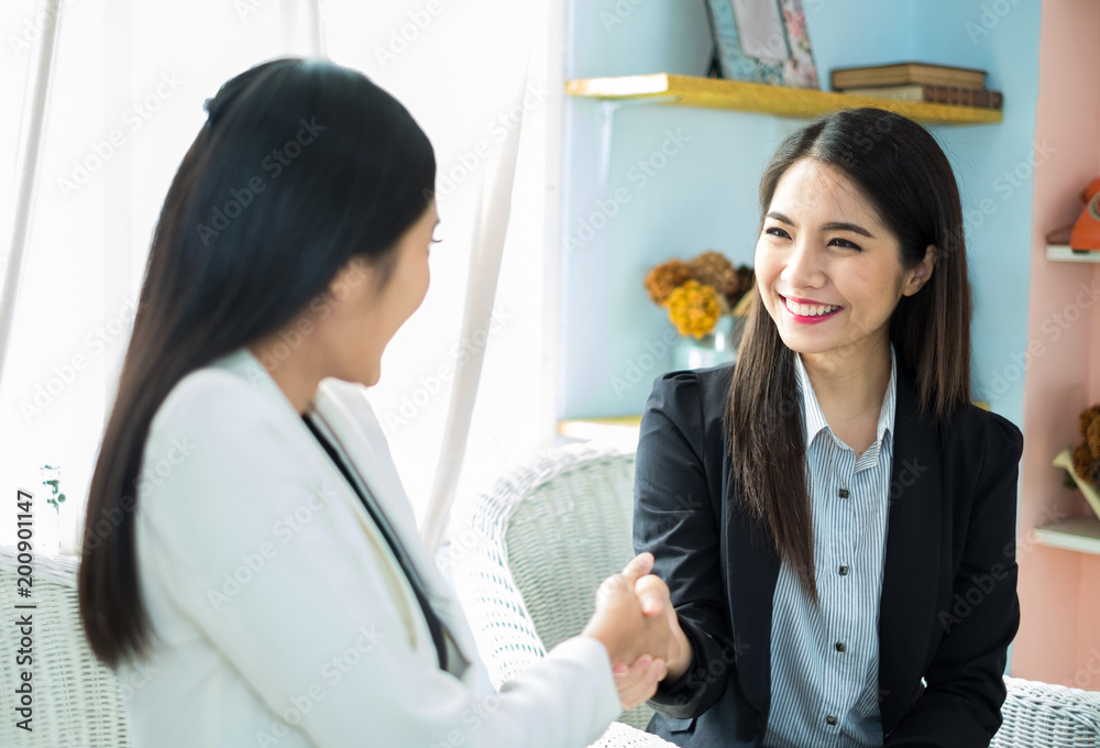 年轻的亚洲女商人在现代办公室，在会议和sh期间与同事讨论业务