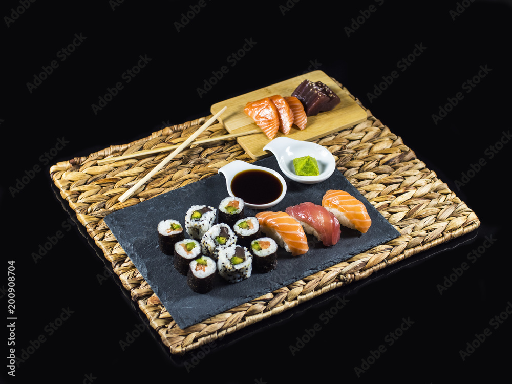 Sushi Set on Slate an Bamboo plate with Sushi Rolls and Wasabi on Black Background