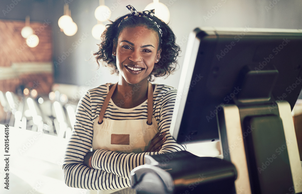 Smiling waitress standing by an order terminal in a restaurant