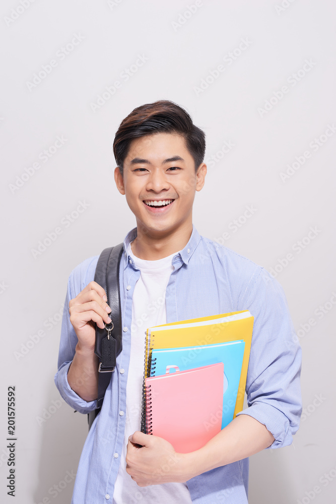 Confident asian handsome student holding books