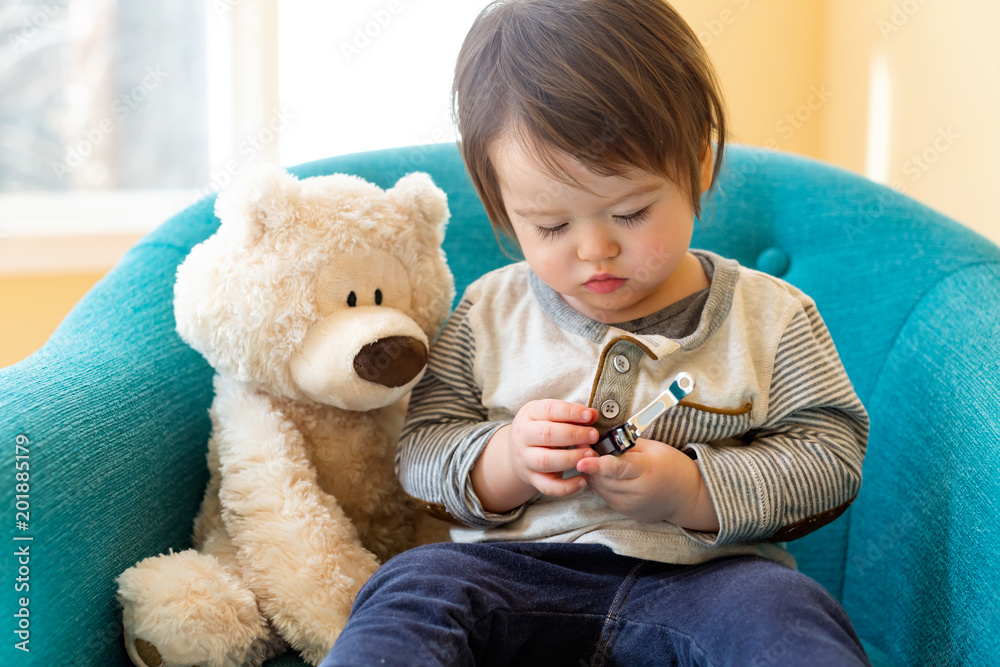 Toddler boy learning to use a nail clipper