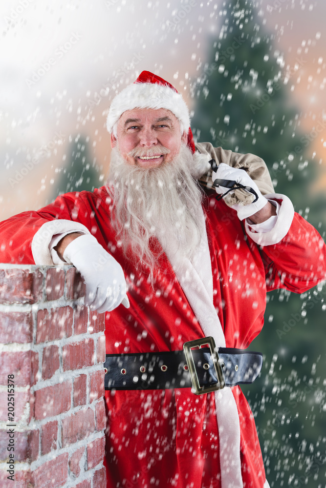 Portrait of Santa Claus carrying bag full of gifts against fir tree forest