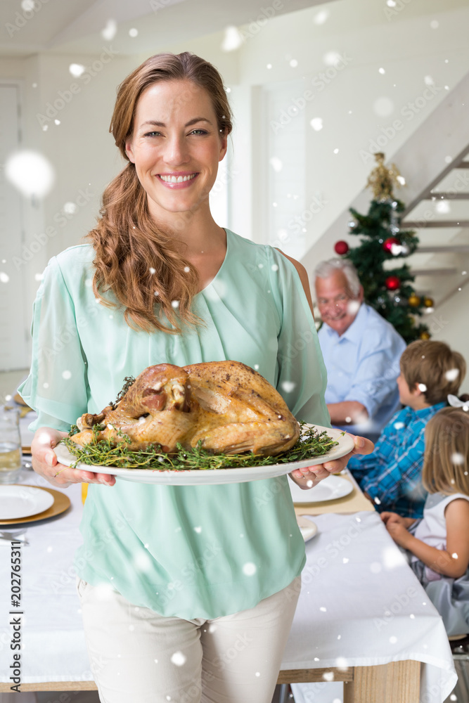 Happy mother with Christmas meal against snow falling