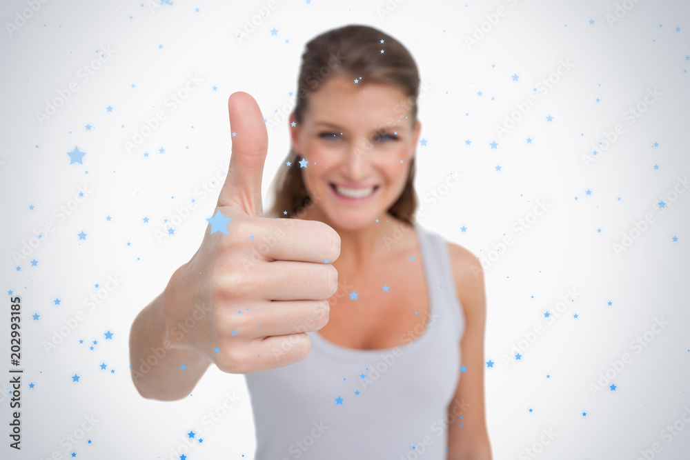 Smiling woman with the thumb up against snow falling