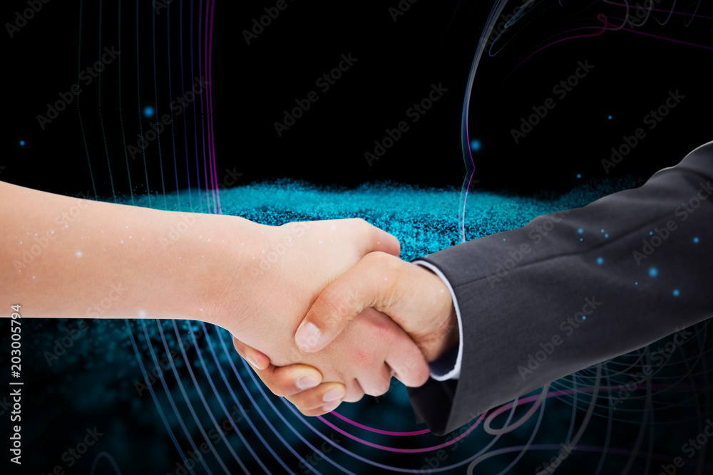 Close up of a handshake against abstract glowing black background