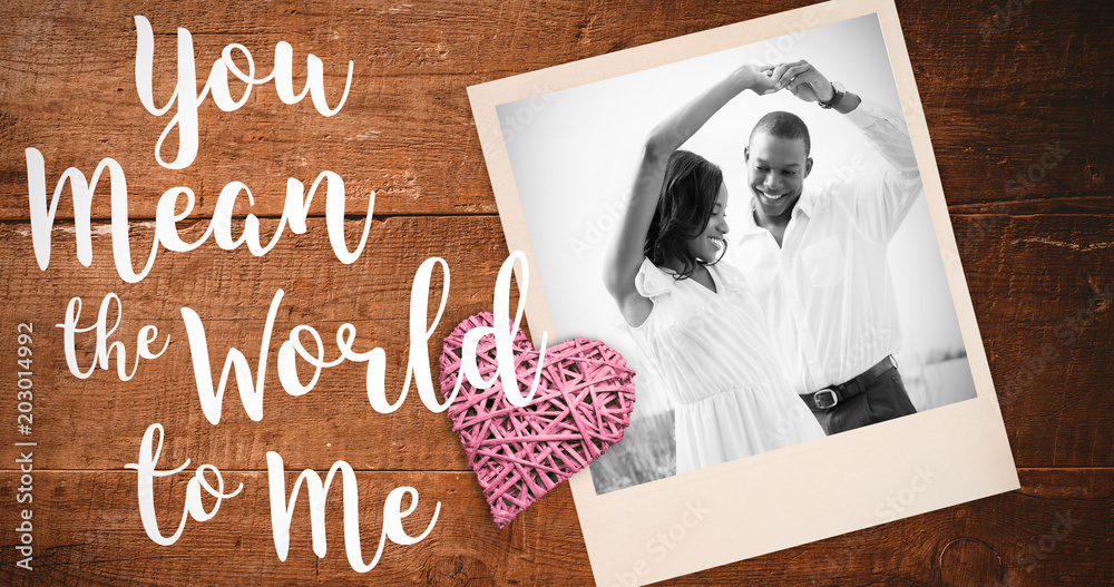 Romantic couple dancing and smiling against overhead of wooden planks