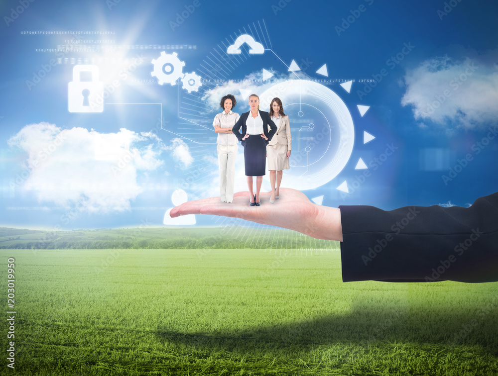 Team of businesswomen looking at camera against sunny green landscape