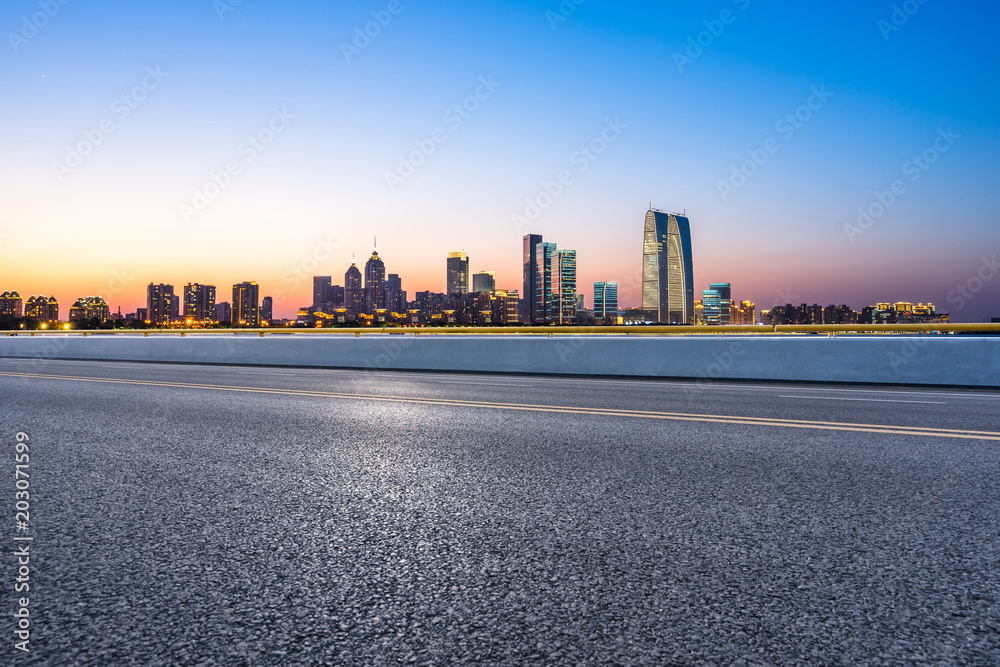 empty asphalt road with city skyline