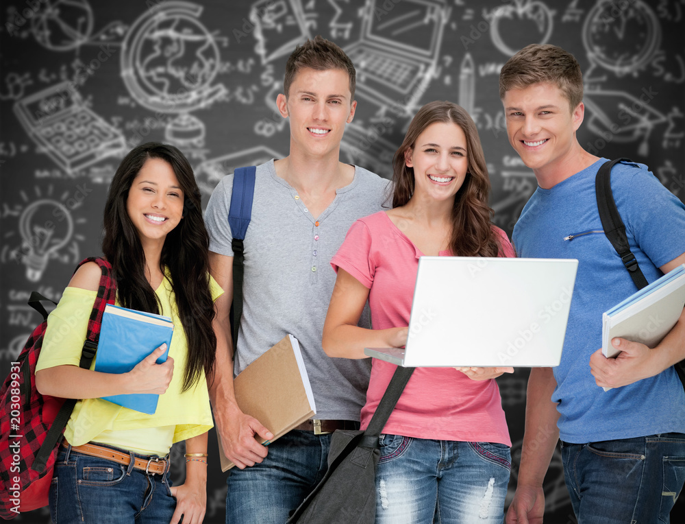 A smiling group of students holding a laptop while looking at the camera against black background