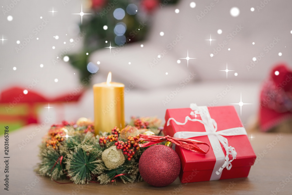 Candle and wreath on table for christmas against snow