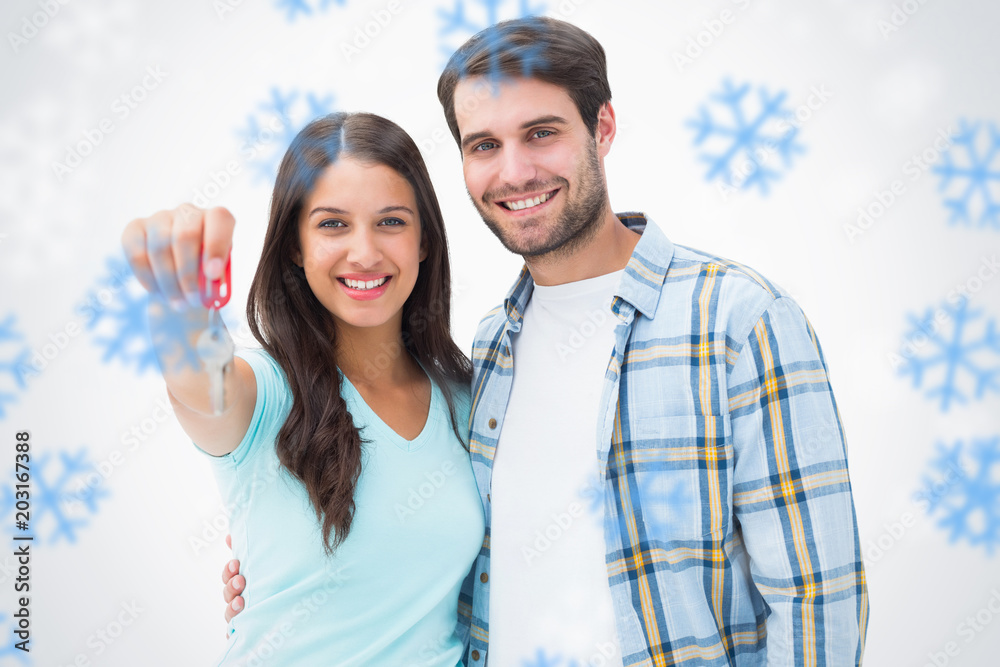 幸福的年轻夫妇在雪花中展示新房钥匙