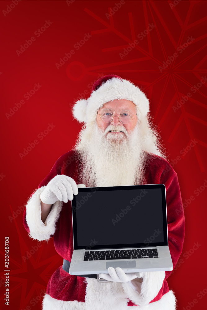 Santa Claus presents a laptop against red background