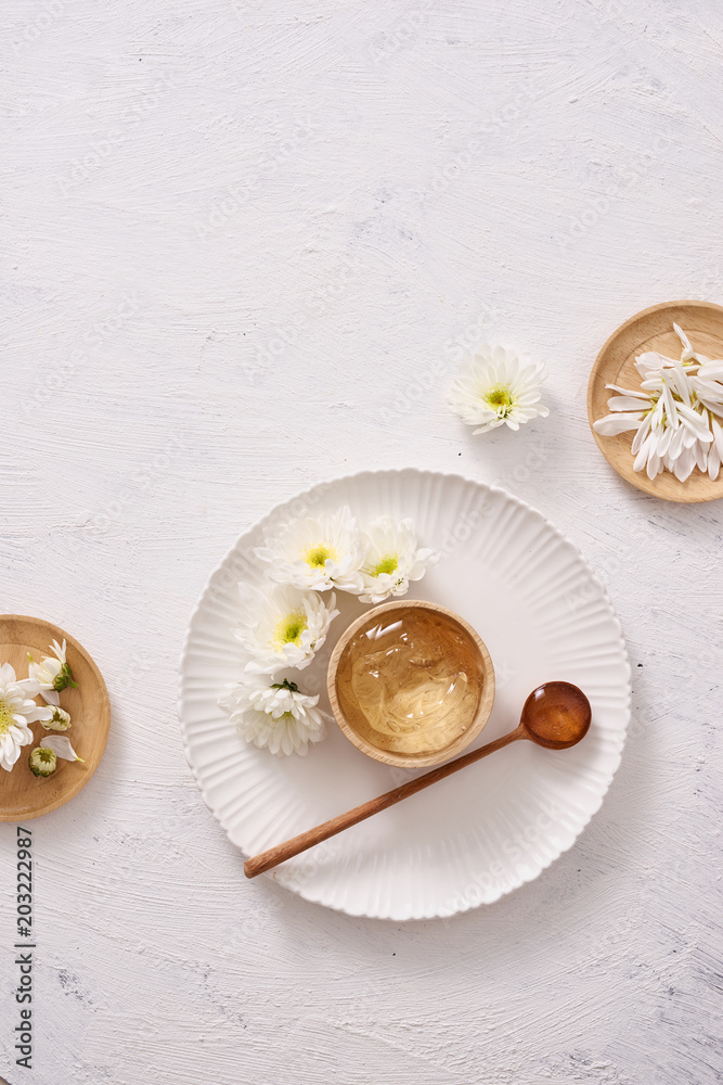 spa setting with cosmetic gel, leaves on white table background