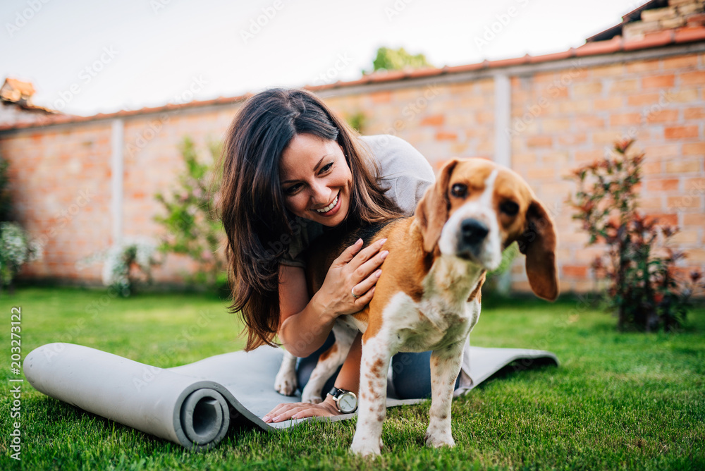 女孩在院子里和她的小猎犬玩耍。