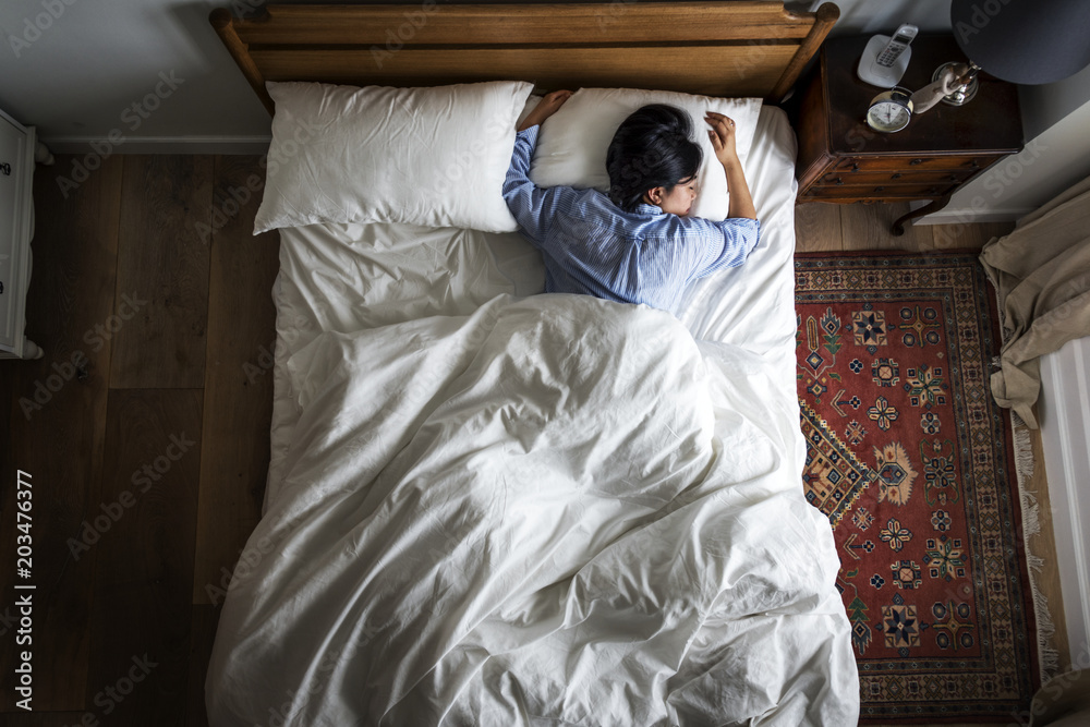 Asian woman on the bed sleeping by herself