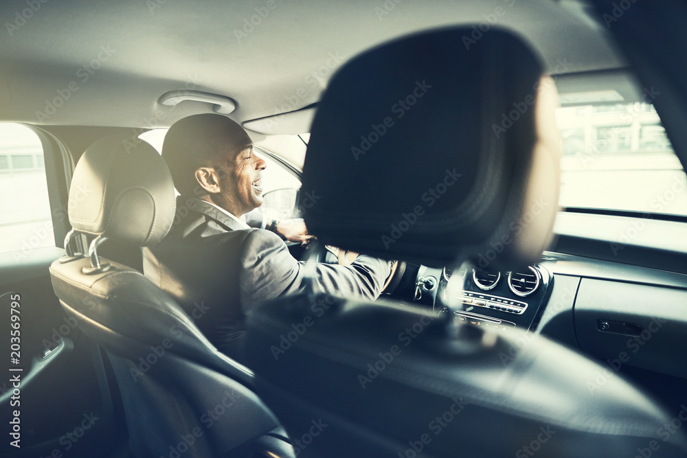 African businessman laughing while driving through the city