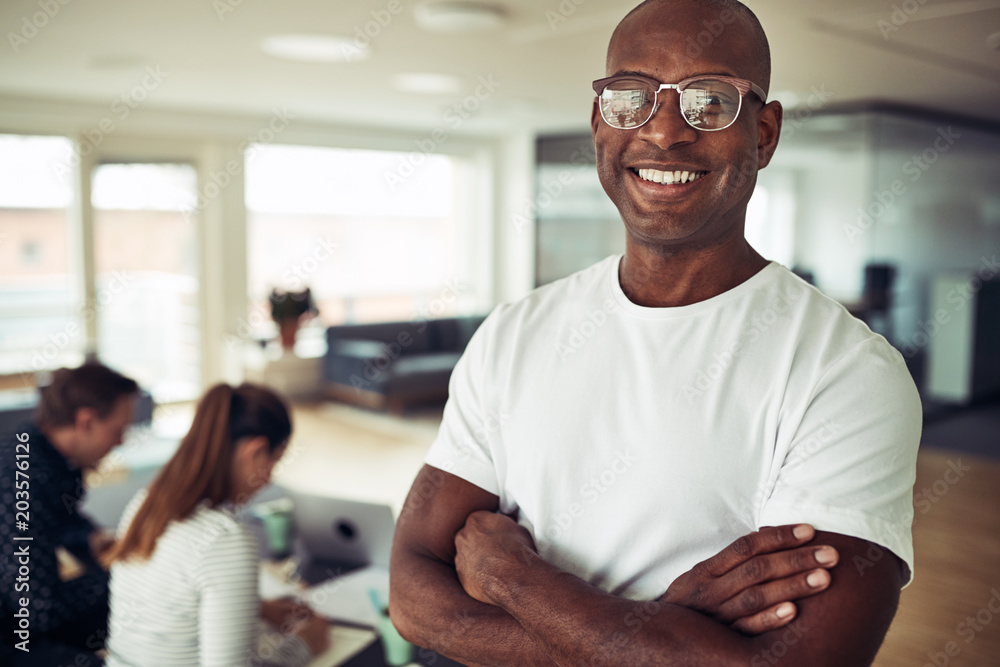 Confident African businessman smiling with colleagues working in