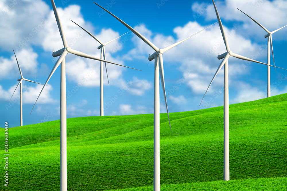 Wind turbines farm on a green grass hills.