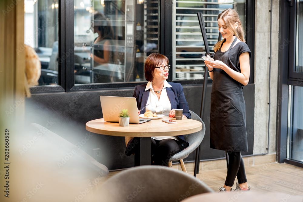 Waitress with businesswoman in the cafe