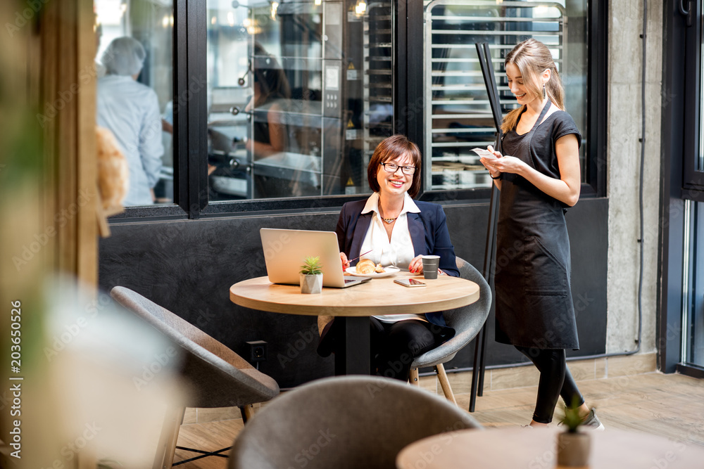 Waitress with businesswoman in the cafe