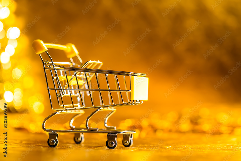 Shopping cart retail concept on golden background