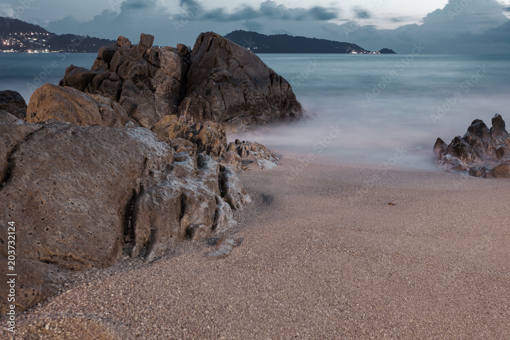 长时间暴露的岩石海景，背景为自然成分。