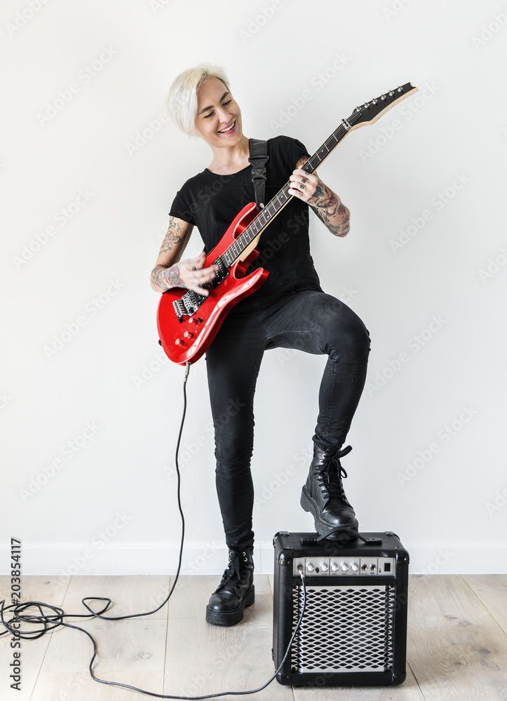 Tattooed woman playing electric guitar