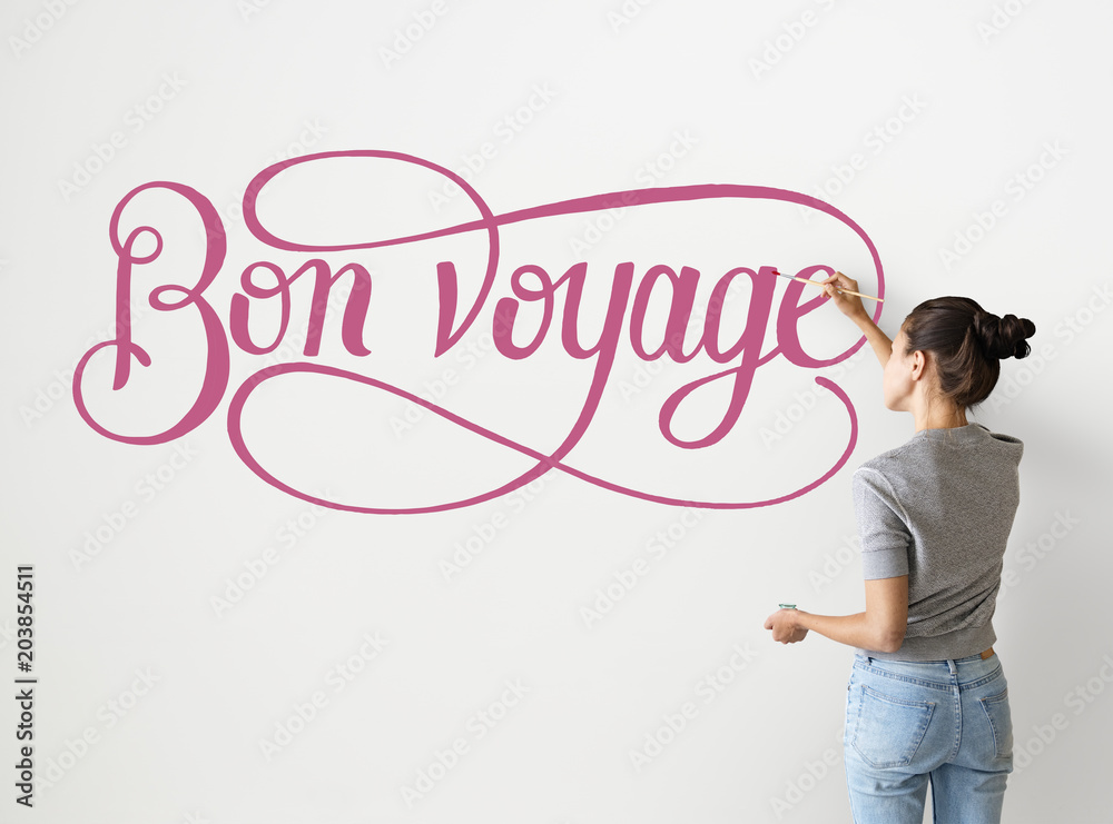 Artist woman writing Bon Voyage on the wall