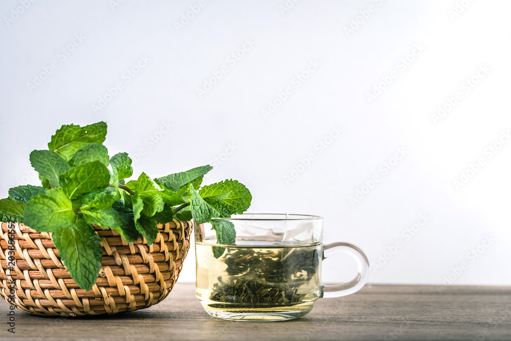 Close up a glass cup of mint tea with green fresh peppermint leaves , relaxation and healthy drink