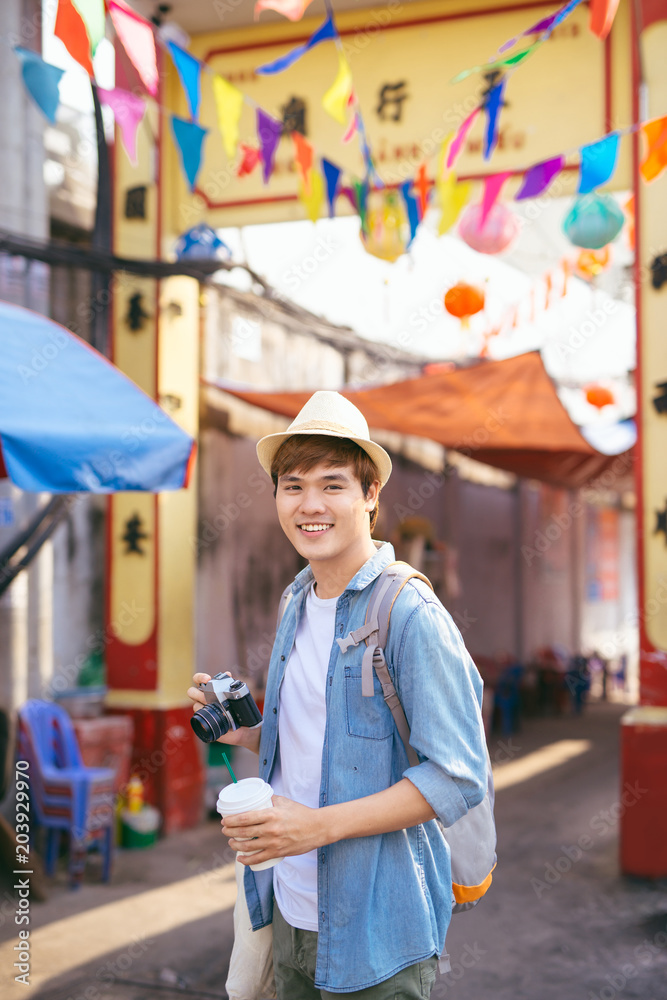 年轻的亚洲男子旅行者在街头市场购物