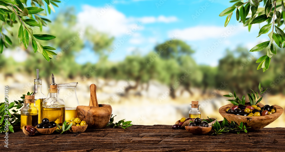 Fresh harvested olives with oil, placed on wooden table