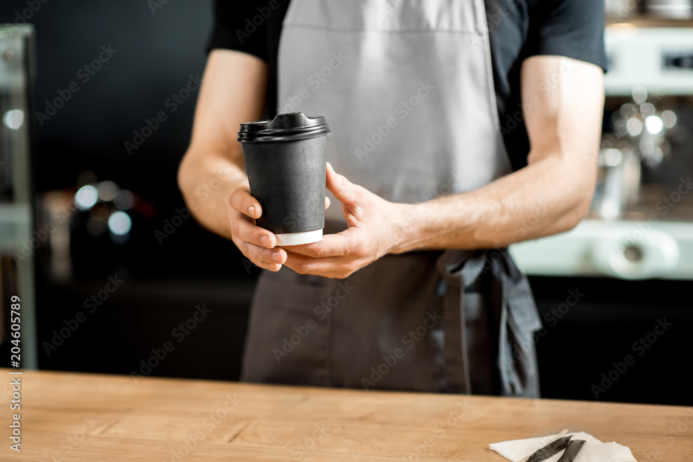 Barista holding coffee cups indoors