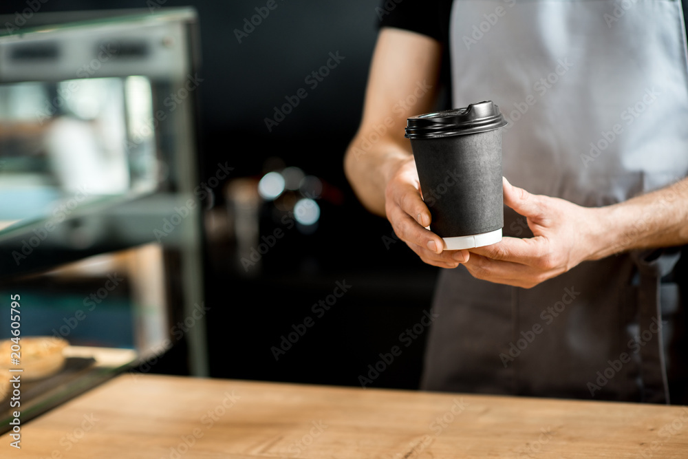 Barista holding coffee cups indoors