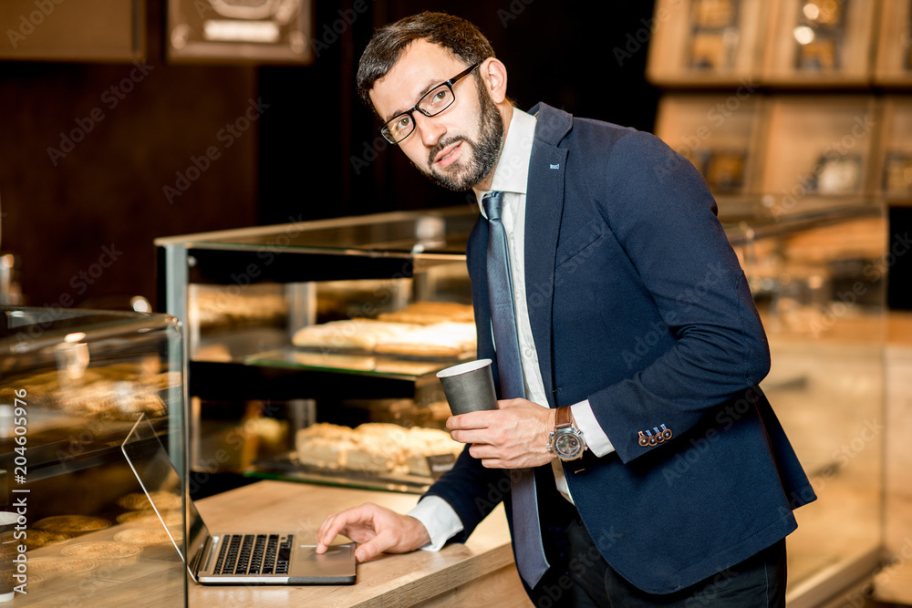 Pastry shop owner working with laptop