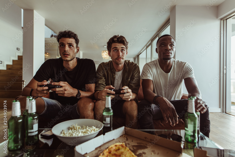 Friends playing video game sitting at home