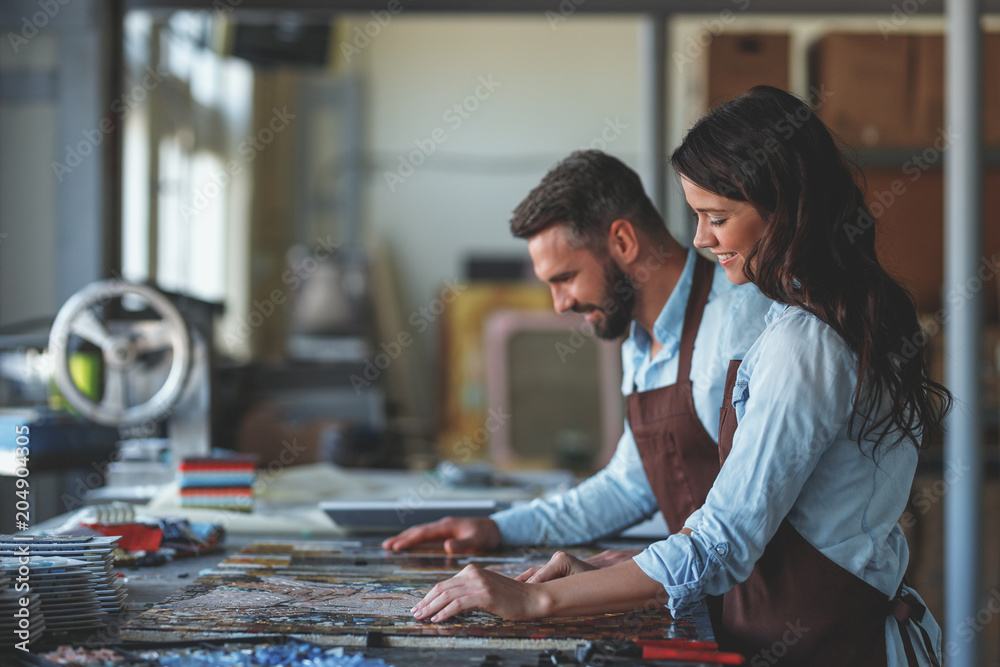 Smiling people with a mosaic in studio