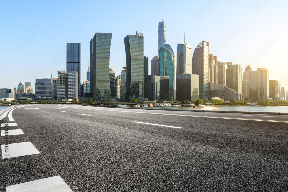 empty asphalt road and city skyline in shanghai at sunset