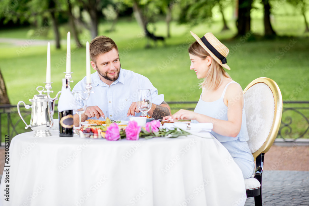 Young couple having romantic breakfast outdoors