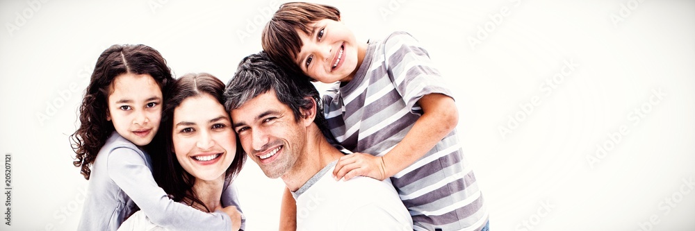 Smiling parents giving their children a piggyback ride 