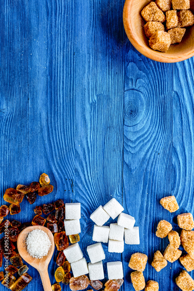 lumps of sugar with bowls sweet set on blue table background top