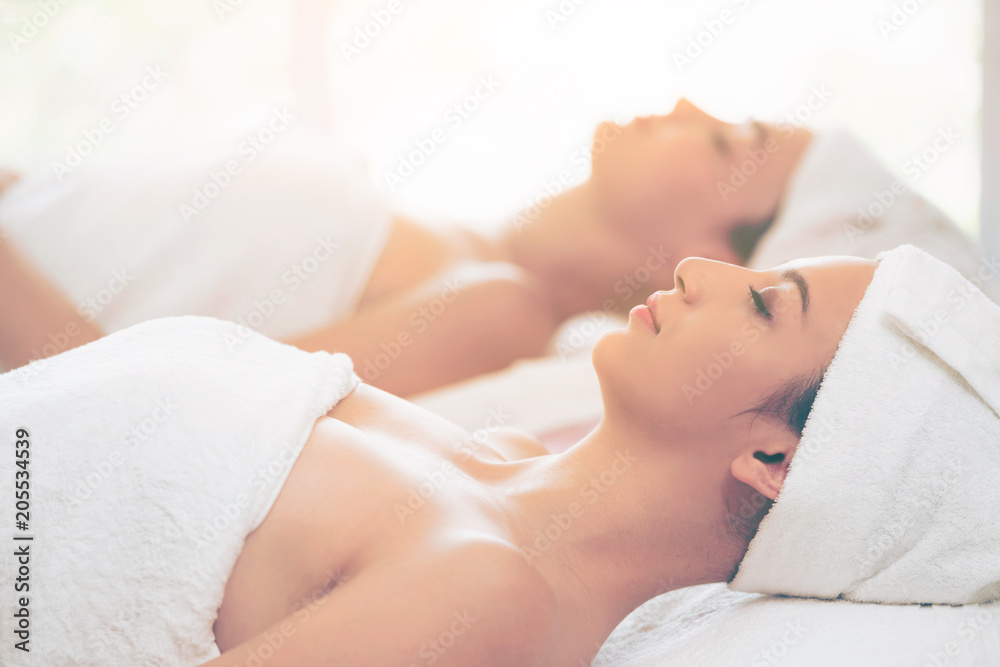 Relaxed young woman lying on spa bed for massage.