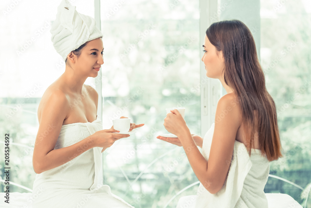 Two women drinking tea in luxury day spa.