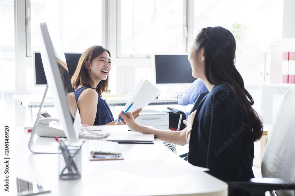 女性たちはオフィスで楽しそうに会話している