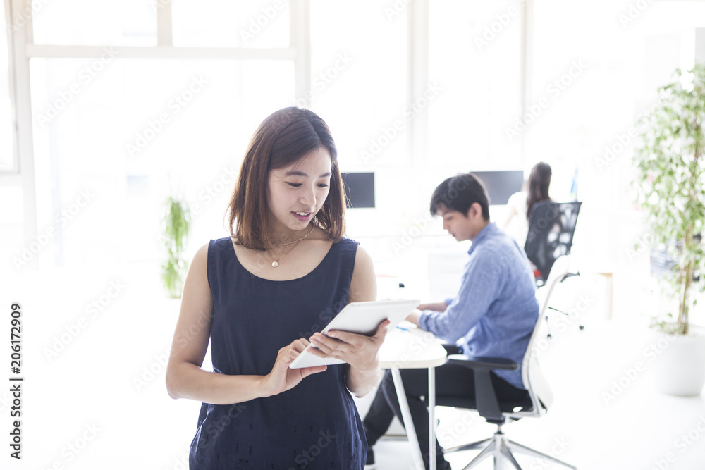 電子タブレットを持っている女性会社員