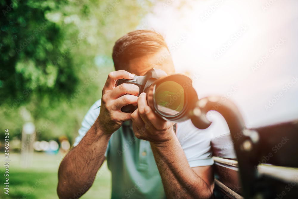 Close-up image of photographer outdoors. Lens flare.